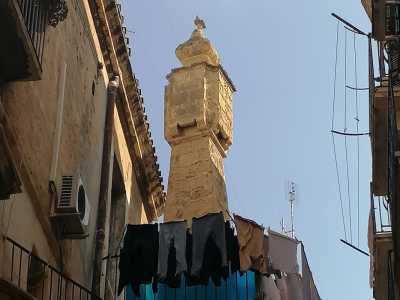 La sua forma � infatti curiosa. Di color ocra e costruito in tufo, poggia su una colonna da cui svetta con una sagoma che presenta quattro lati sporgenti forati...